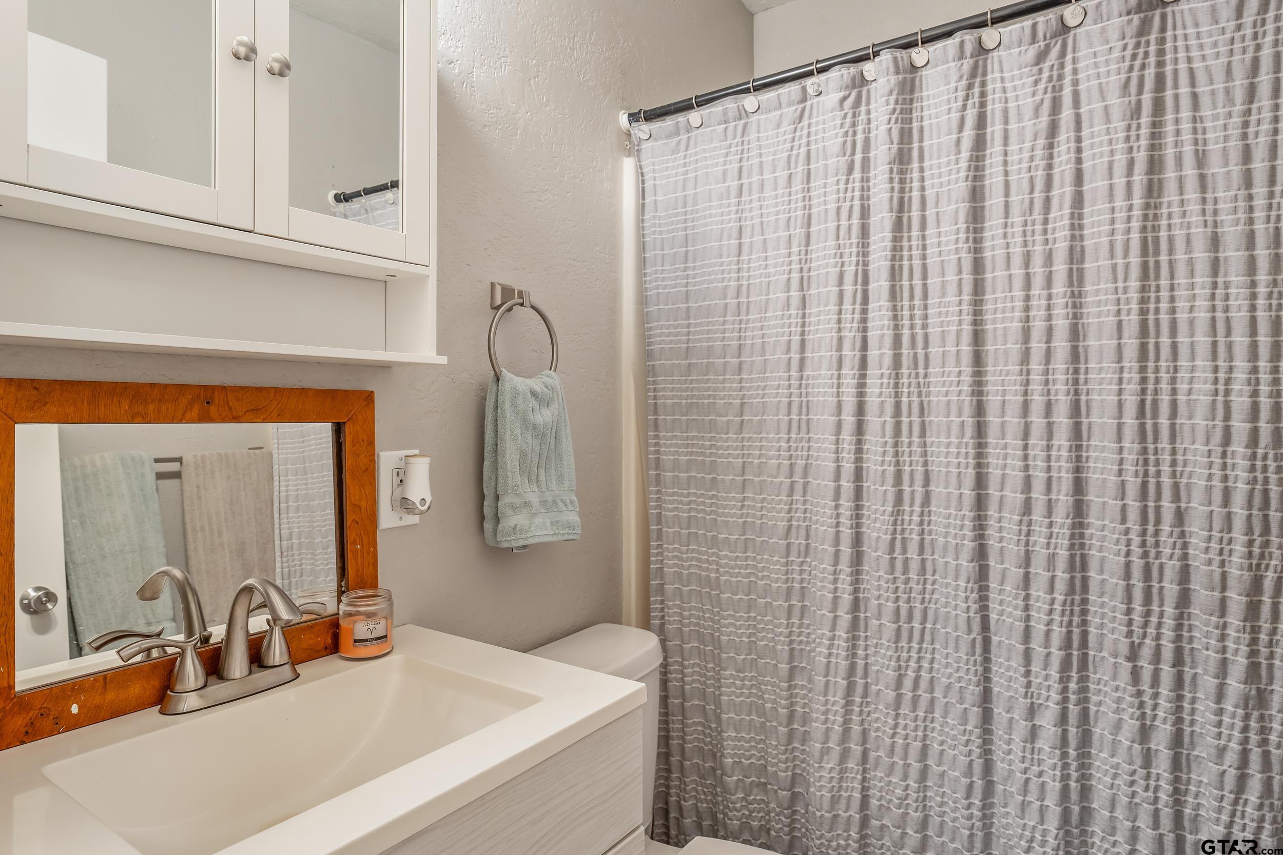 402 Bonner Street Rusk, TX 75785 - Photo 8 of 25 a bathroom with a sink a toilet and mirror