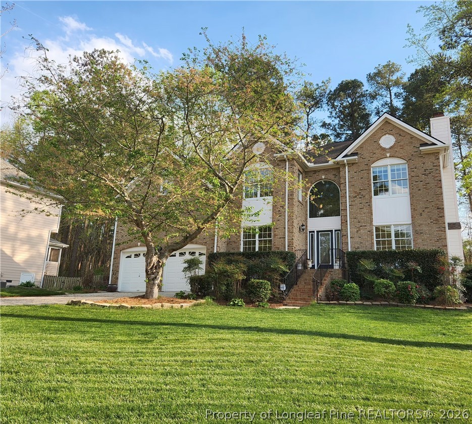 203 Ticonderoga Road Cary, NC 27519 - Photo 1 of 18 a front view of a house with a garden
