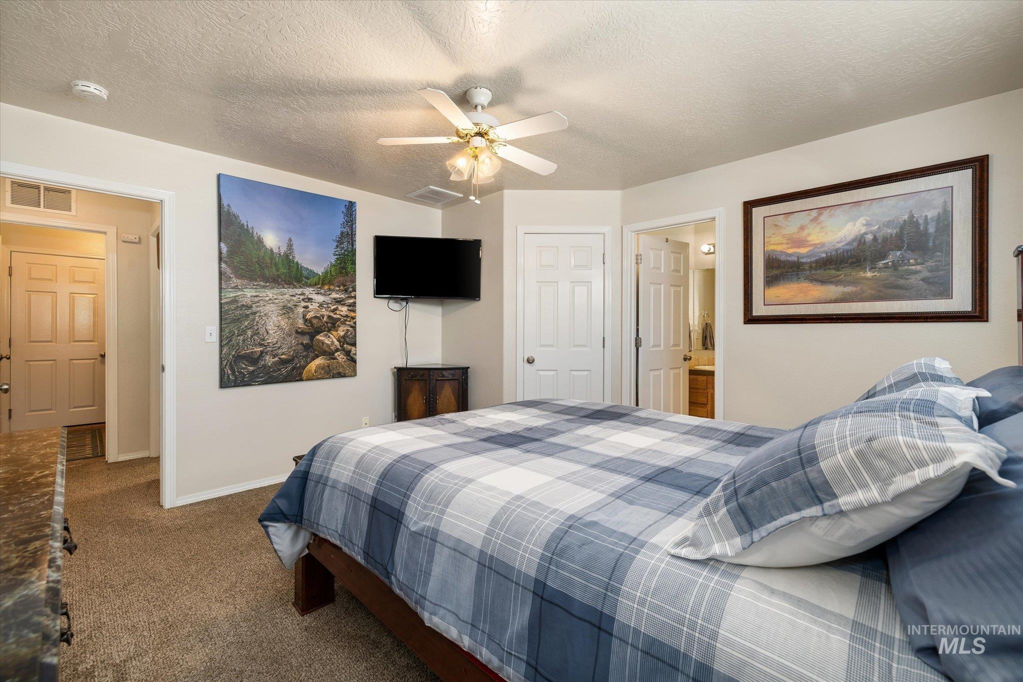 5401 Barkley Way Caldwell, ID 83607 - Photo 12 of 35 Carpeted bedroom featuring neutral wall tones, a ceiling fan with integrated lighting, and multiple white paneled doors