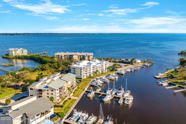 an aerial view of ocean and residential houses with outdoor space
