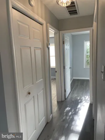 a view of a hallway with wooden floor and entryway