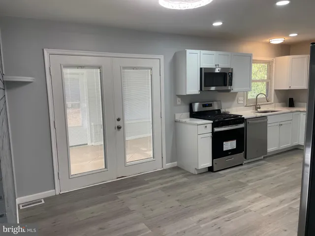 a kitchen with white cabinets and appliances