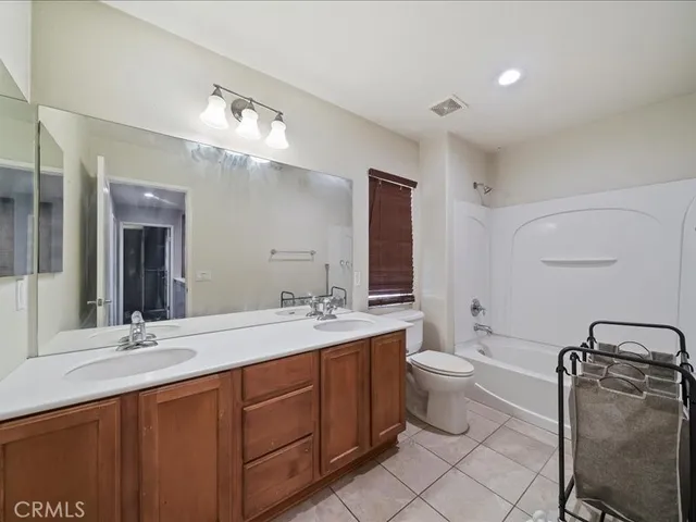 a bathroom with a double vanity sink toilet and mirror