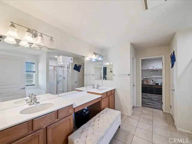 a spacious bathroom with a shower a sink and a mirror