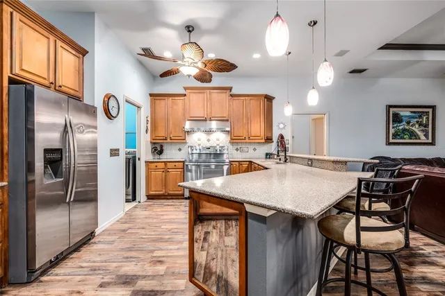 a kitchen with stainless steel appliances granite countertop a sink a stove and a refrigerator