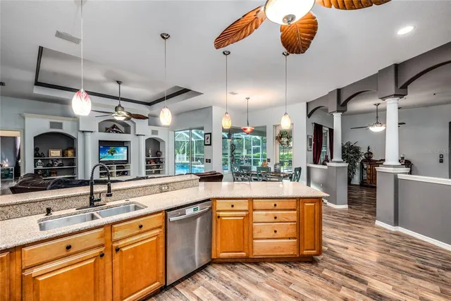 a large kitchen with a large counter space a sink and stainless steel appliances