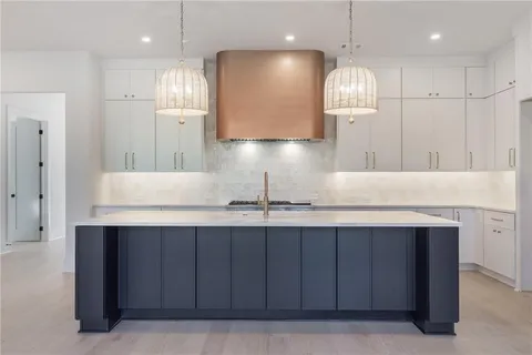 a kitchen with kitchen island granite countertop a sink and a refrigerator