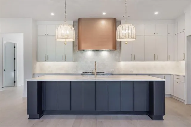 a kitchen with kitchen island granite countertop a sink and a refrigerator
