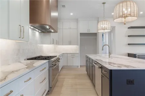 a kitchen with granite countertop a sink stove and cabinets