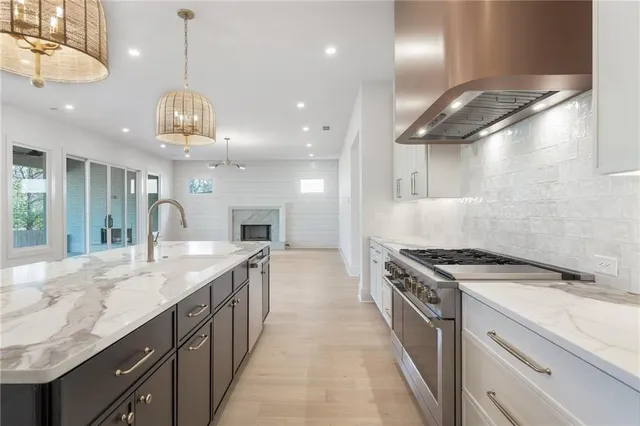 a kitchen with a sink and a stove with wooden floor