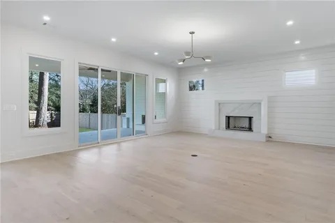 an empty room with windows and fireplace