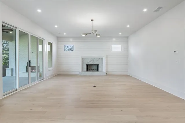 an empty room with fireplace and windows