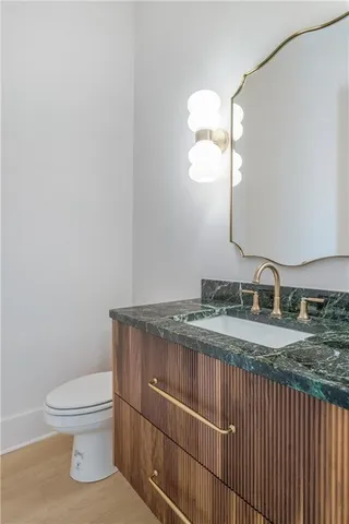 a bathroom with a granite countertop toilet sink and mirror