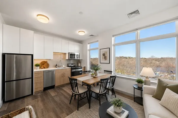 a kitchen with a dining table chairs and refrigerator
