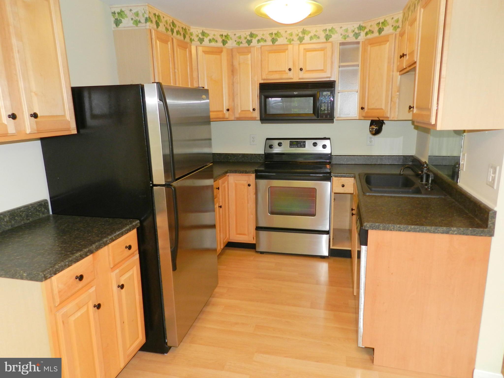 17567 Kohlhoss Road Poolesville, MD 20837 - Photo 10 of 25 a kitchen with stainless steel appliances a refrigerator sink and microwave
