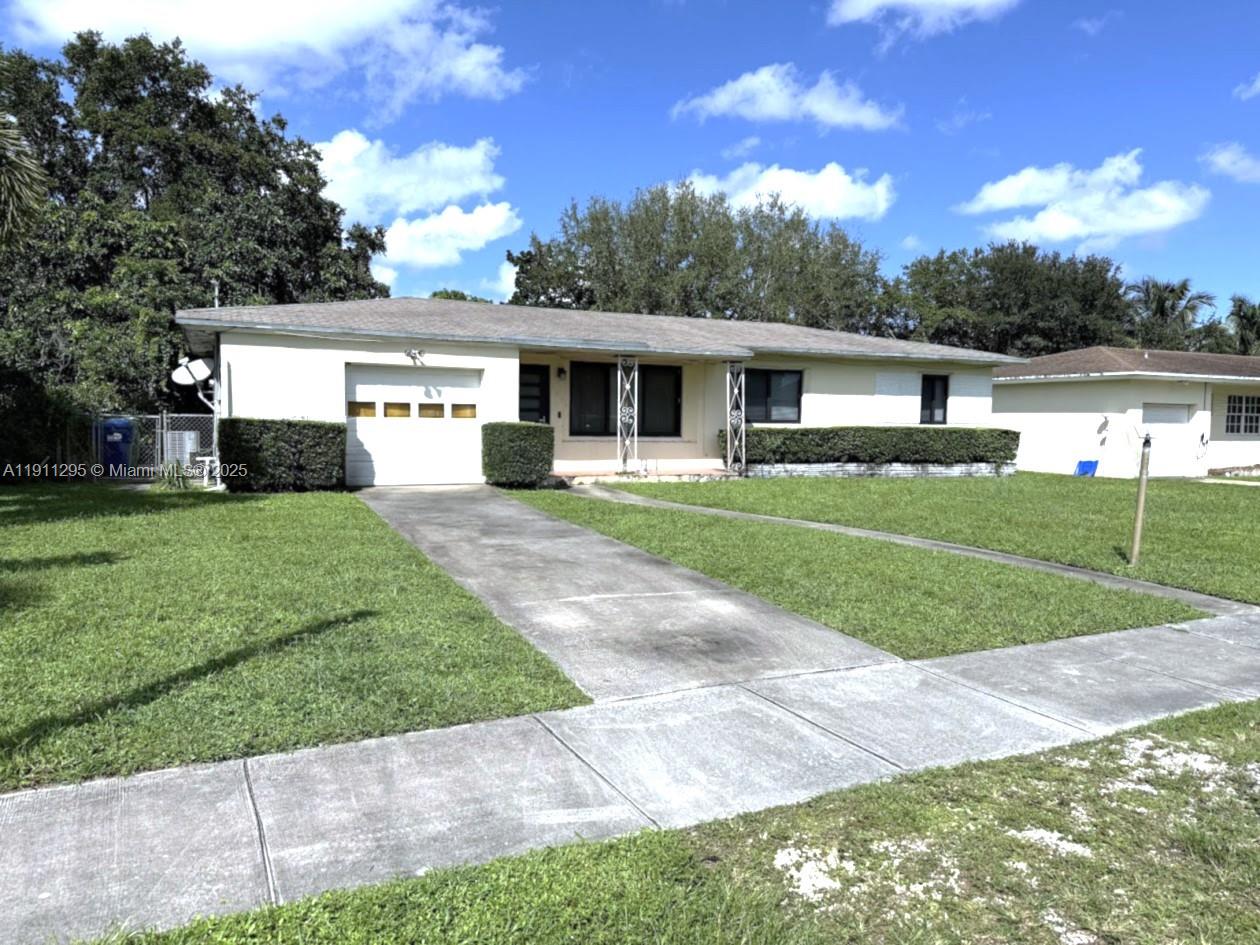 1041 Northwest 150th Street Miami, FL 33168 - Photo 2 of 27 a front view of a house with yard
