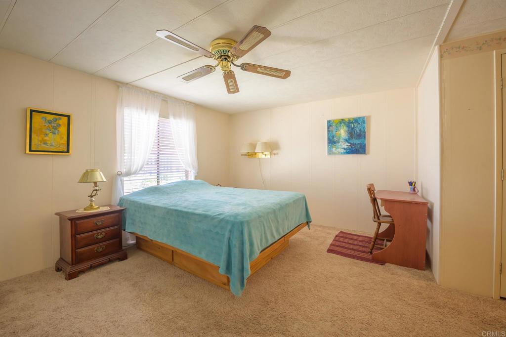 4650 Dulin Road, Unit 120 Fallbrook, CA 92003 - Photo 12 of 34 a bedroom with a bed and a chandelier