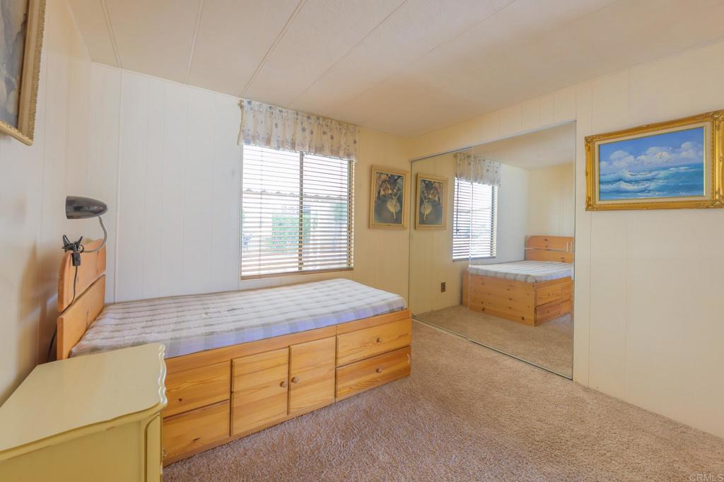 4650 Dulin Road, Unit 120 Fallbrook, CA 92003 - Photo 13 of 34 a spacious bedroom with a bed and a dresser next to a window