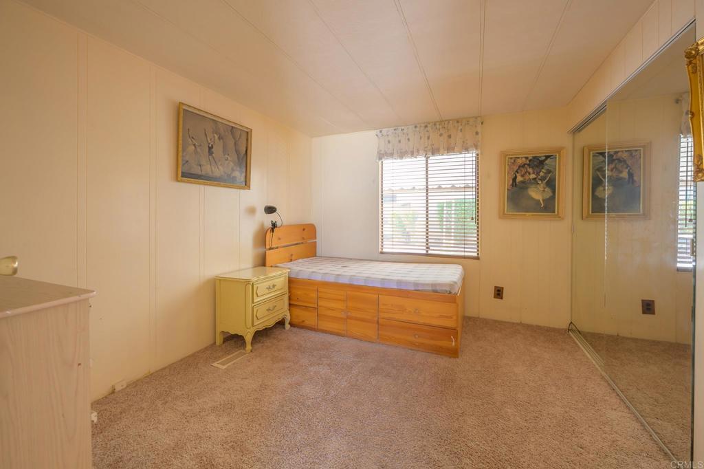 4650 Dulin Road, Unit 120 Fallbrook, CA 92003 - Photo 14 of 34 a spacious bedroom with a bed and a table