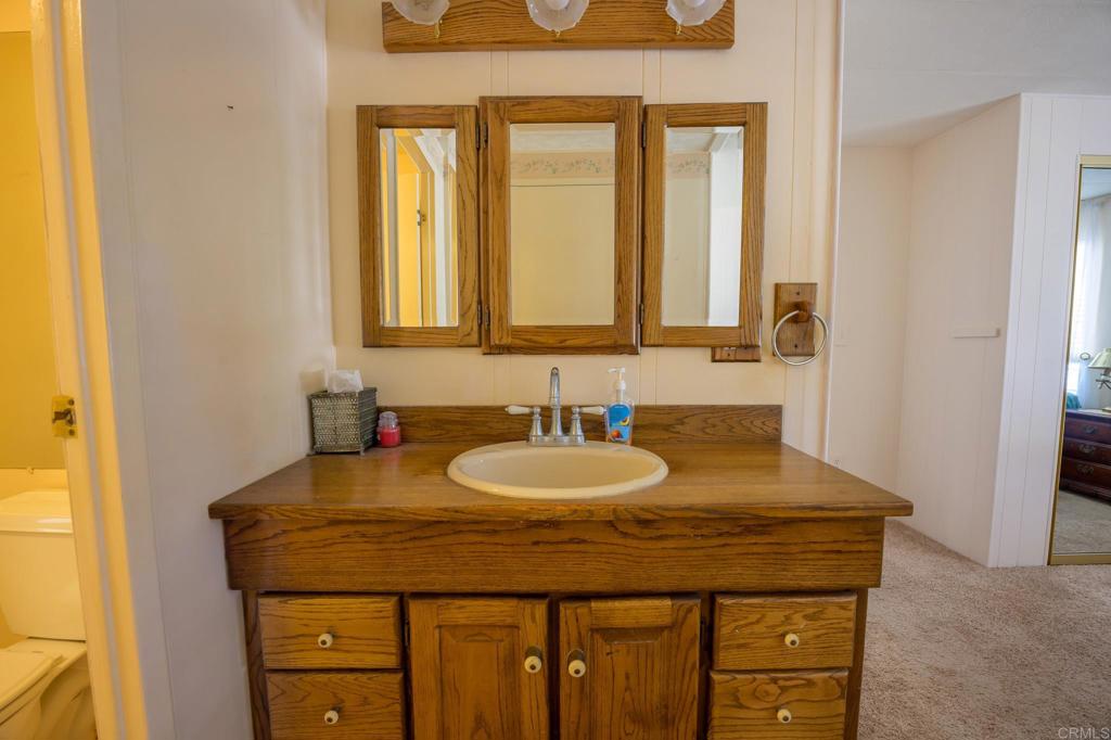4650 Dulin Road, Unit 120 Fallbrook, CA 92003 - Photo 10 of 34 a bathroom with a granite countertop sink and a mirror