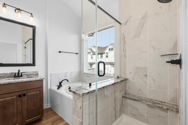 a bathroom with a granite countertop sink mirror and a bathtub