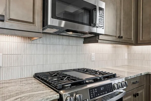 a stove top oven sitting inside of a kitchen