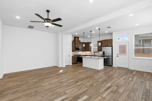 a large kitchen with a lot of counter space and wooden floor