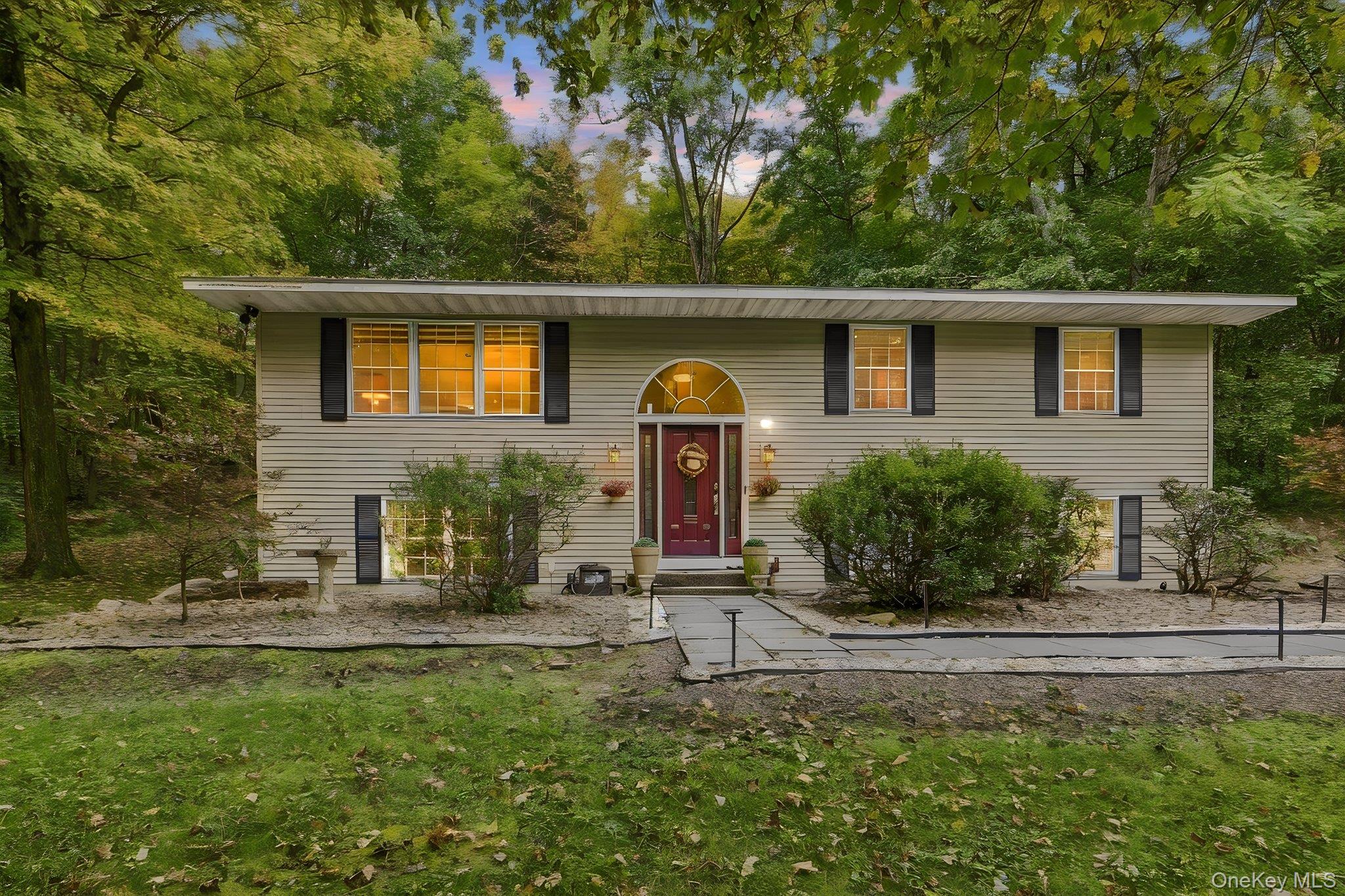 48 Mac Farlane Road Wappingers Falls, NY 12590 - Photo 1 of 47 Bi-level residence featuring light-toned siding, a vibrant red entry door with an arched transom, and black window shutters