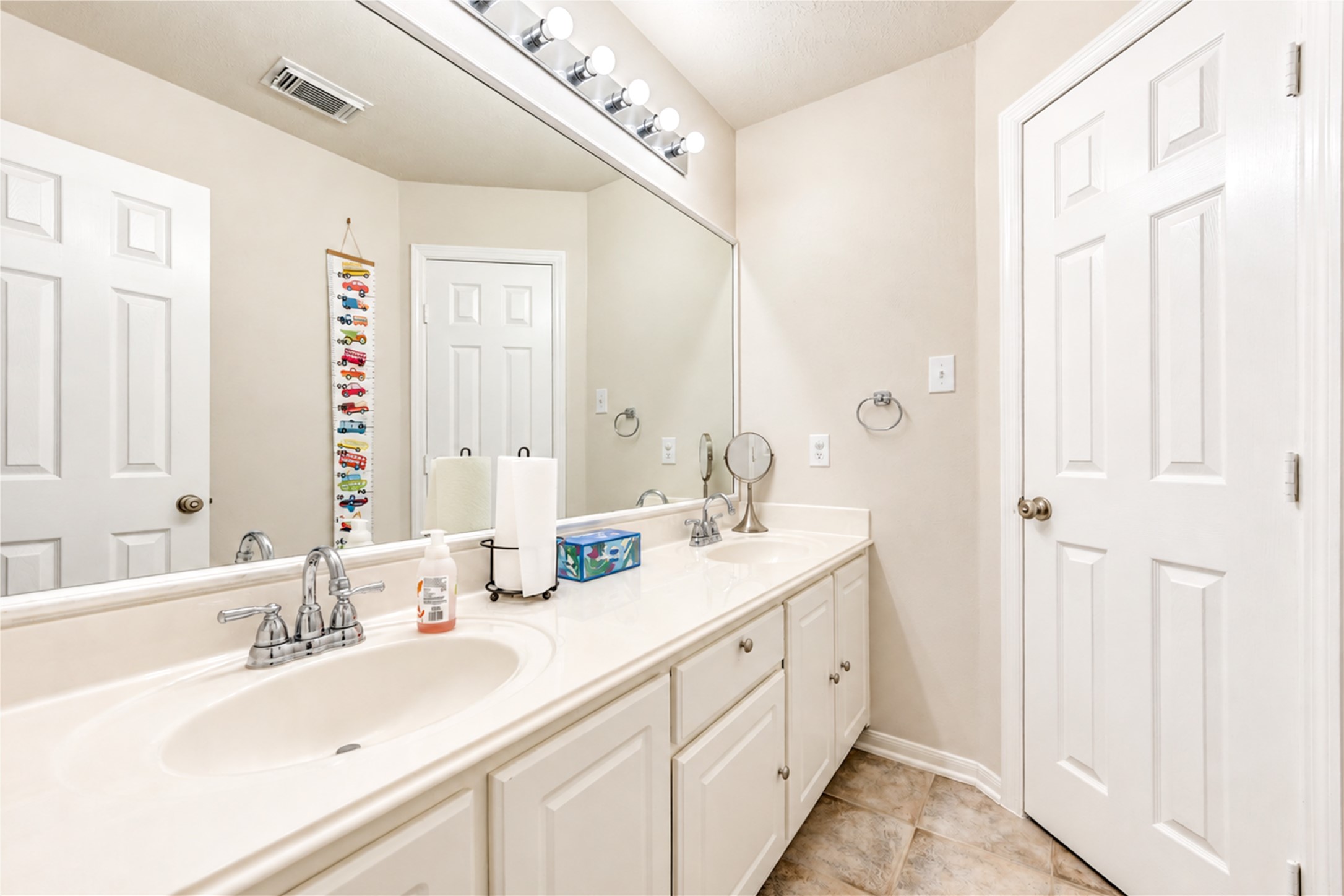 12806 Ridge Bank Lane Houston, TX 77041 - Photo 31 of 44 Bright and spacious bathroom featuring a double vanity with ample storage, framed by a large mirror and elegant lighting.