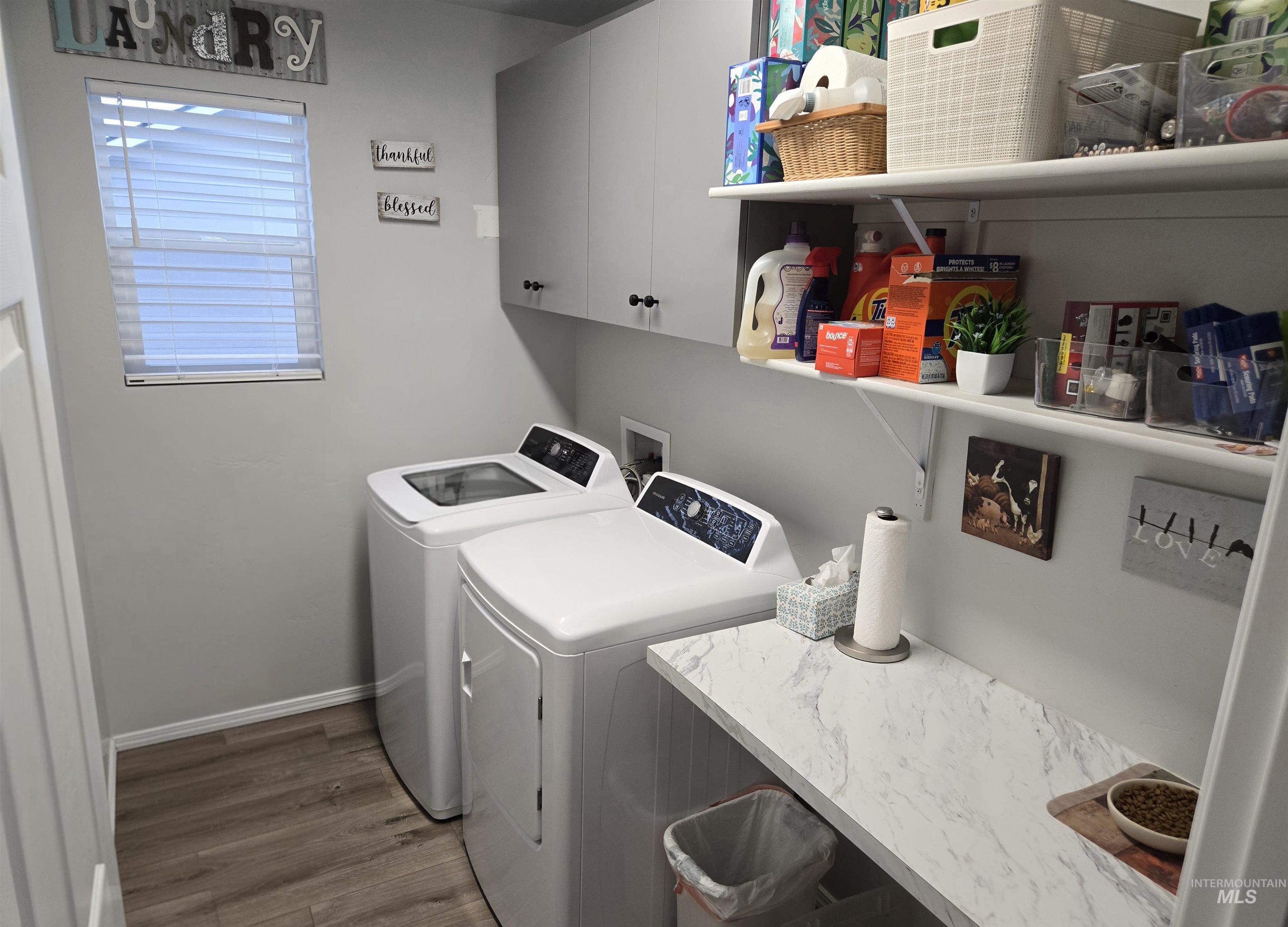4098 East Mets Street Nampa, ID 83686 - Photo 26 of 34 Washroom with cabinet space, dark wood-style flooring, and washer and dryer