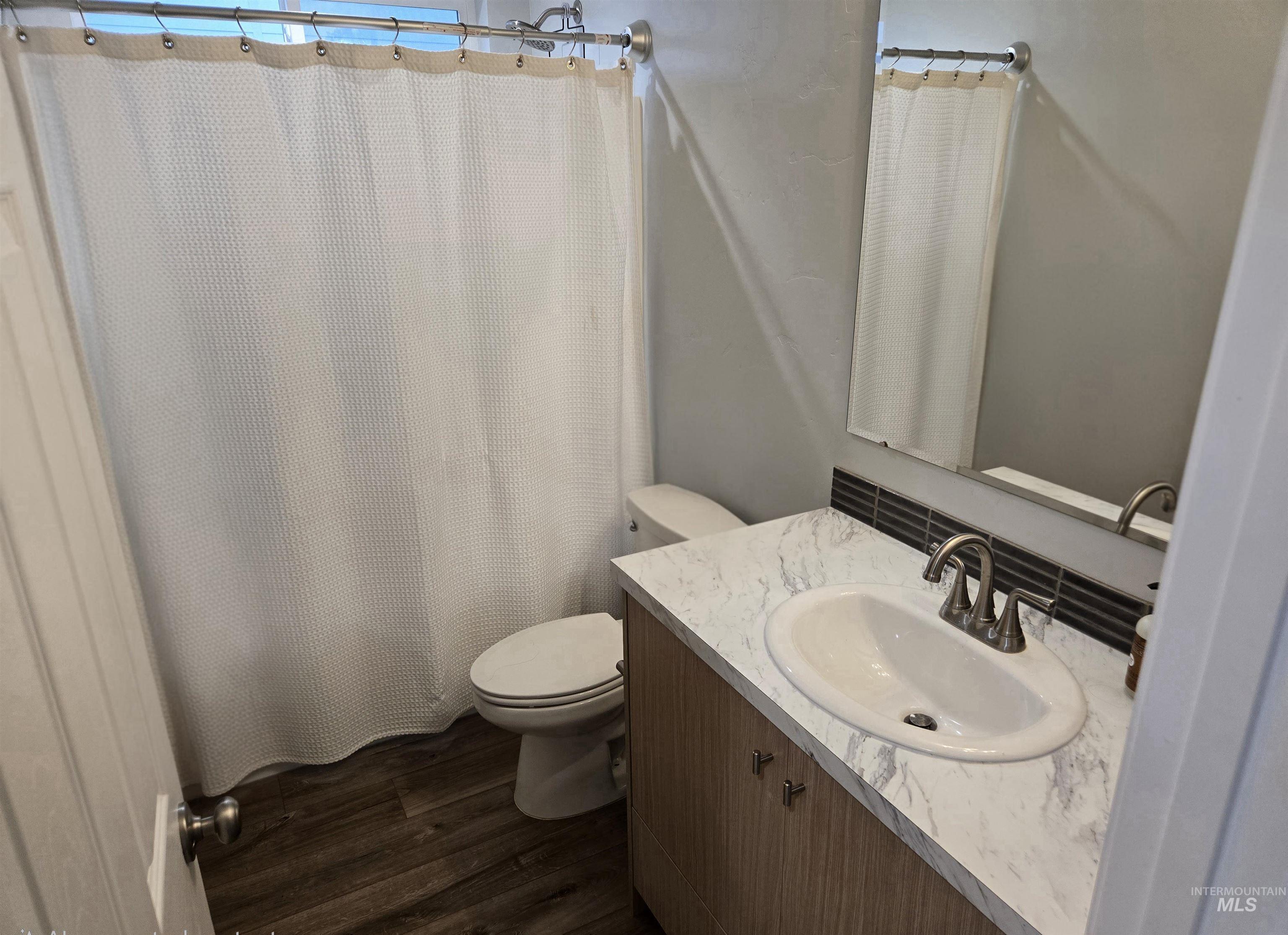 4098 East Mets Street Nampa, ID 83686 - Photo 27 of 34 Bathroom with vanity, curtained shower, and dark wood-type flooring