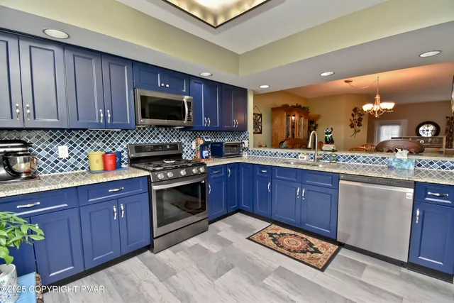 a kitchen with stainless steel appliances granite countertop wooden cabinets a stove top oven a sink and dishwasher
