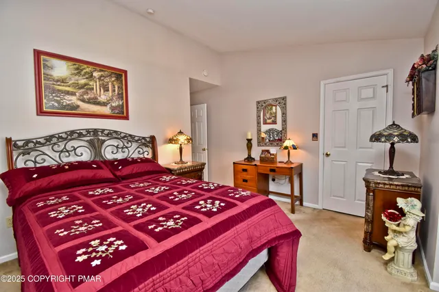 a bedroom with a bed and dresser with chair