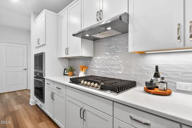 a kitchen with stainless steel appliances granite countertop a sink stove and cabinets