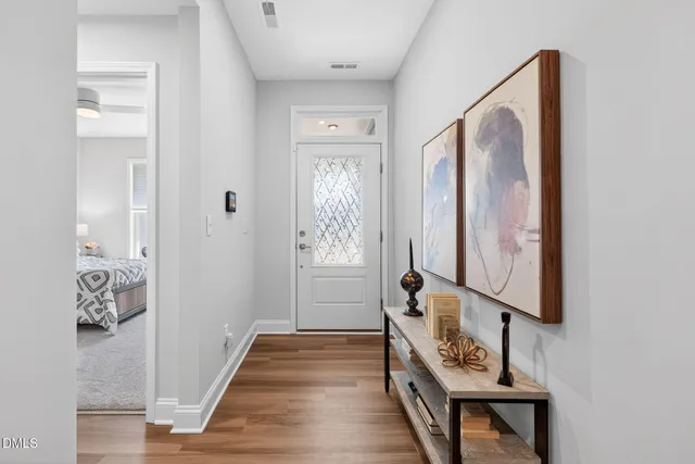 a hallway with front door wooden floor and windows