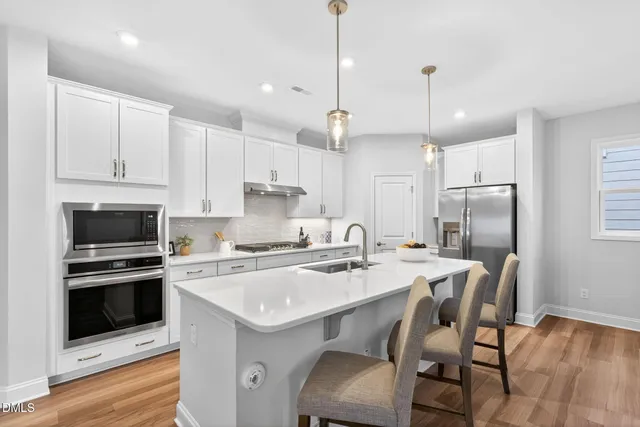 a kitchen with a dining table chairs sink and microwave