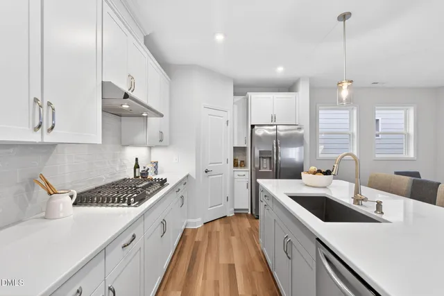 a kitchen that has a sink a stove and chairs