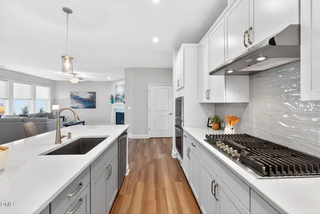 a kitchen with kitchen island a counter space a sink a stove and cabinets