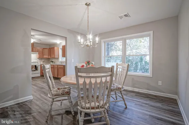 a view of a dining room with furniture a chandelier and wooden floor