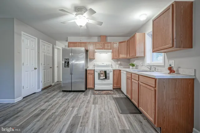 a kitchen with stainless steel appliances a sink a refrigerator and cabinets