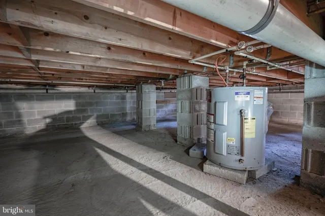a bed sitting in a bedroom next to a window and a chandelier