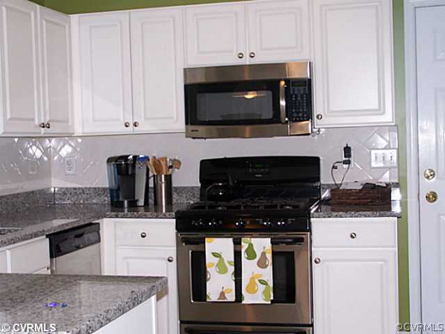1852 Taylor Road Crozier, VA 23039 - Photo 6 of 12 a kitchen with stainless steel appliances granite countertop a stove a microwave and cabinets