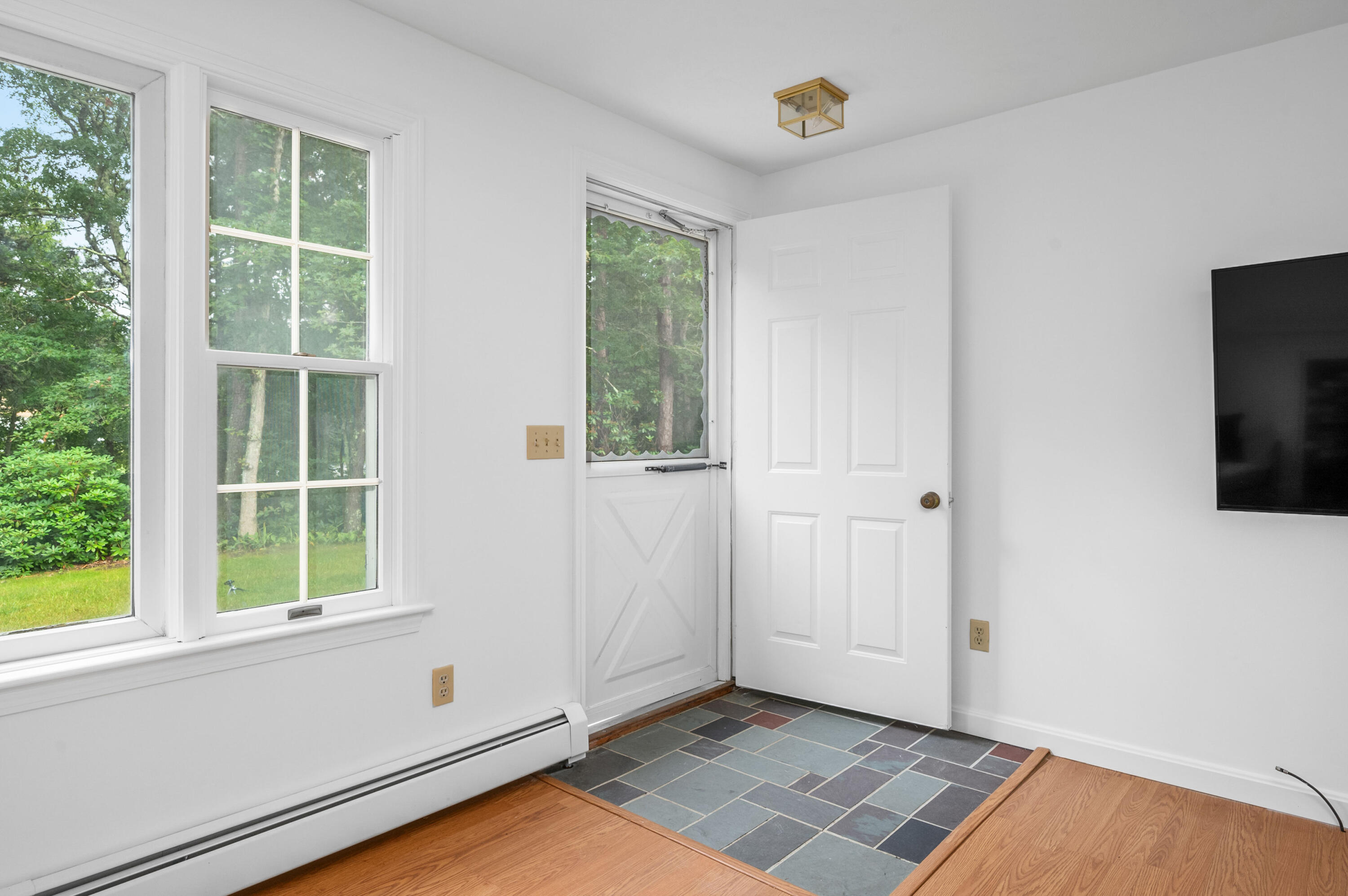 9 Tarragon Circle Cotuit, MA 02635 - Photo 3 of 28 a view of an empty room with a window and wooden floor
