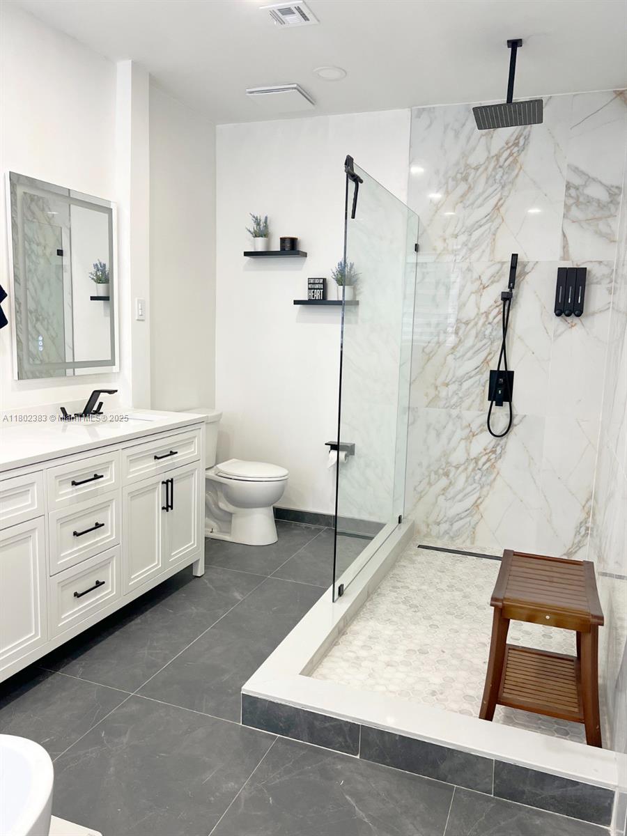 20124 Southwest 129th Place, Unit 20124 Miami, FL 33177 - Photo 18 of 31 a bathroom with a sink a toilet and shower