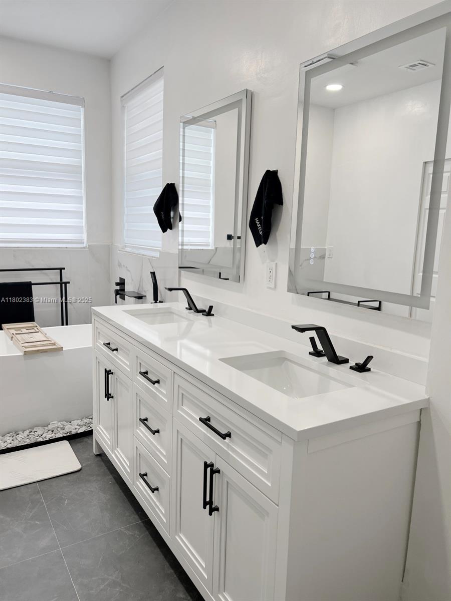 20124 Southwest 129th Place, Unit 20124 Miami, FL 33177 - Photo 22 of 31 a bathroom with a double vanity sink and mirror