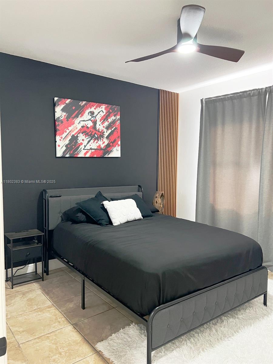 20124 Southwest 129th Place, Unit 20124 Miami, FL 33177 - Photo 28 of 31 a bedroom with a bed and a flat screen tv