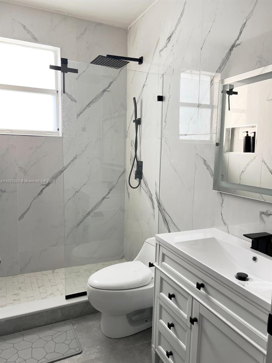 20124 Southwest 129th Place, Unit 20124 Miami, FL 33177 - Photo 30 of 31 a bathroom with a sink a toilet and shower