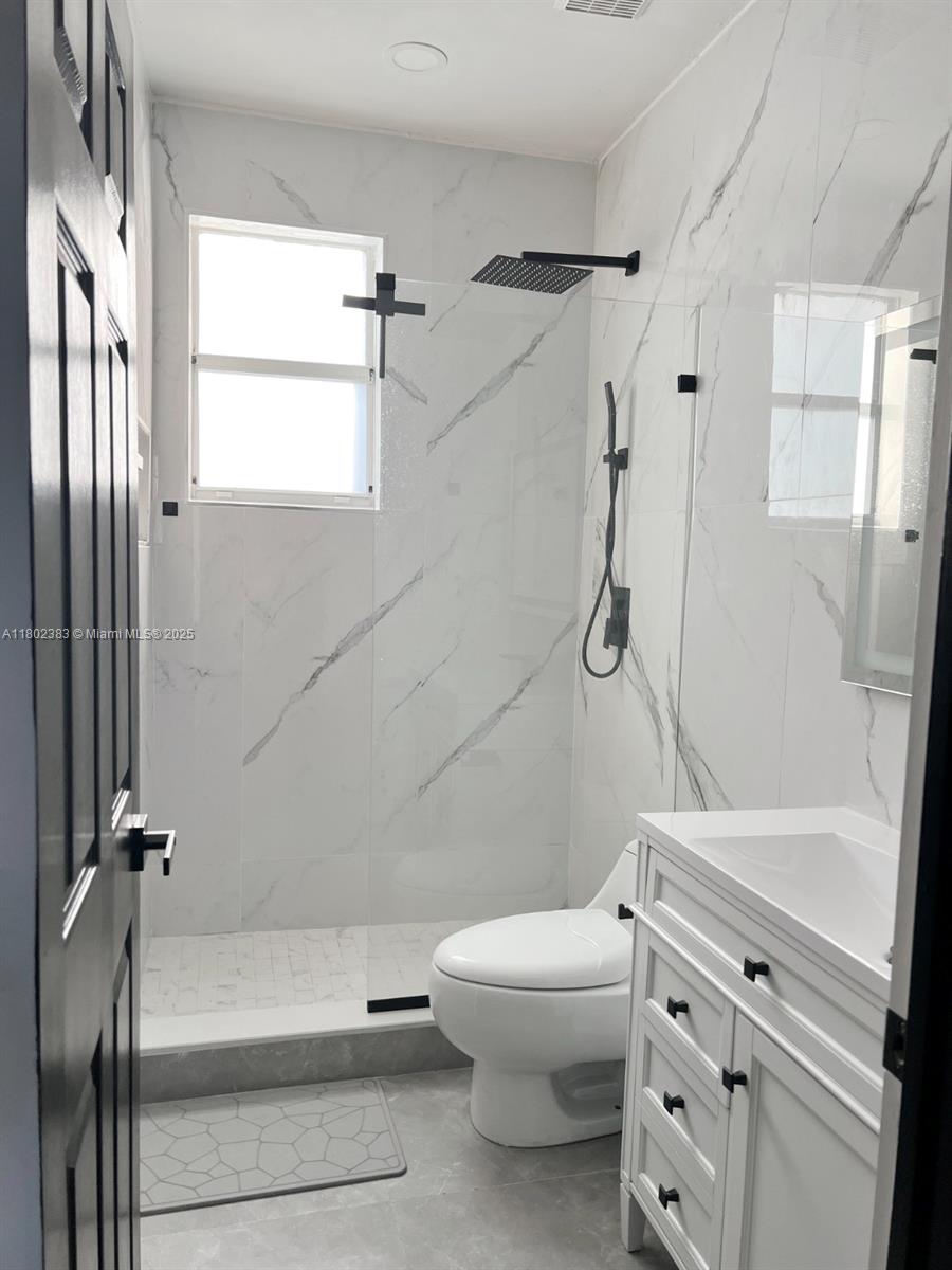 20124 Southwest 129th Place, Unit 20124 Miami, FL 33177 - Photo 31 of 31 a bathroom with a granite countertop toilet sink and shower