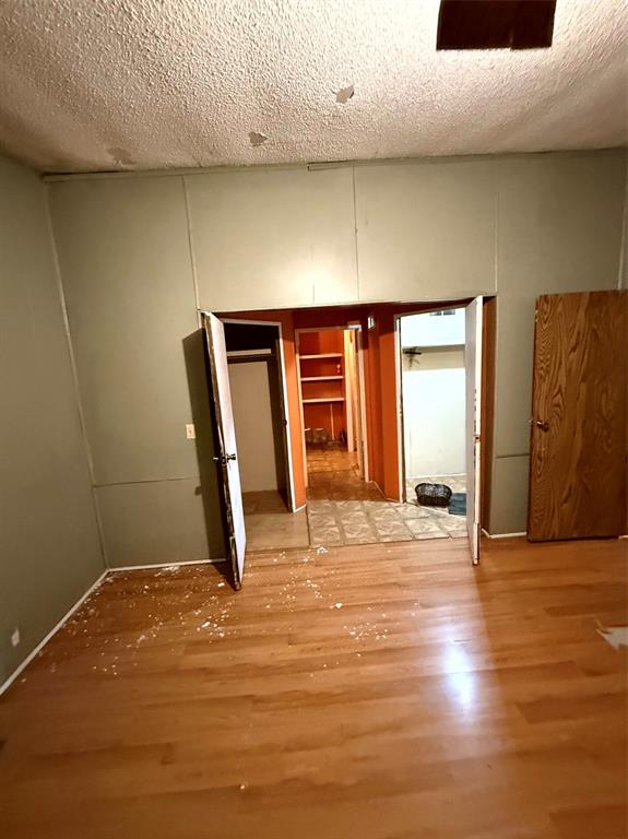 1047 John Wayne Road Kaufman, TX 75142 - Photo 16 of 17 Spare room with a textured ceiling and wood finished floors