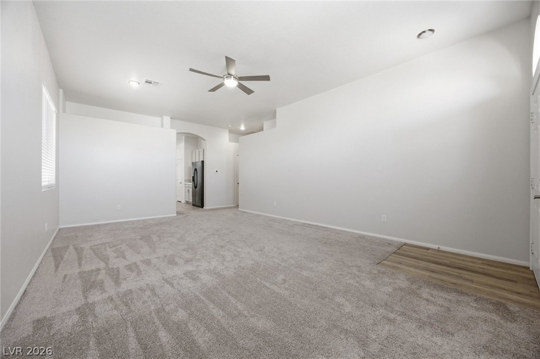 193 Oella Ridge Court Henderson, NV 89012 - Photo 10 of 32 A spacious, naturally illuminated room features plush carpeting and a modern ceiling fan for ultimate comfort.